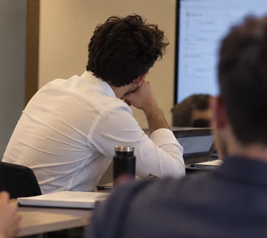 Léo Roussel en réflexion lors d’une réunion, devant des écrans.